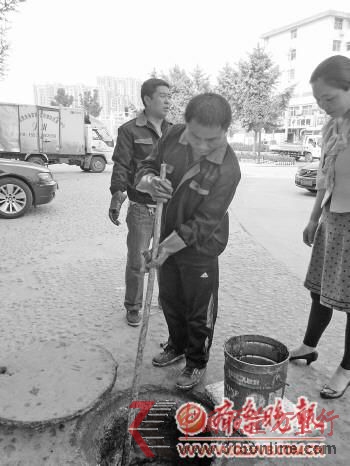 4日,在漁夫碼頭門(mén)口,金信達(dá)工作人員正在挖地溝油。本報(bào)記者 董惠 攝